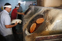 Ancient Kurdish bakery. Bread being baked on the walls of the stone oven.