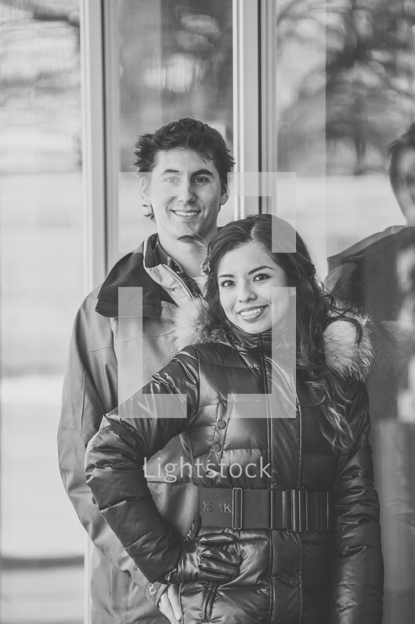 portrait of a couple standing in front of shop windows 