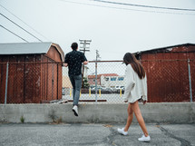 man and woman walking in a parking lot