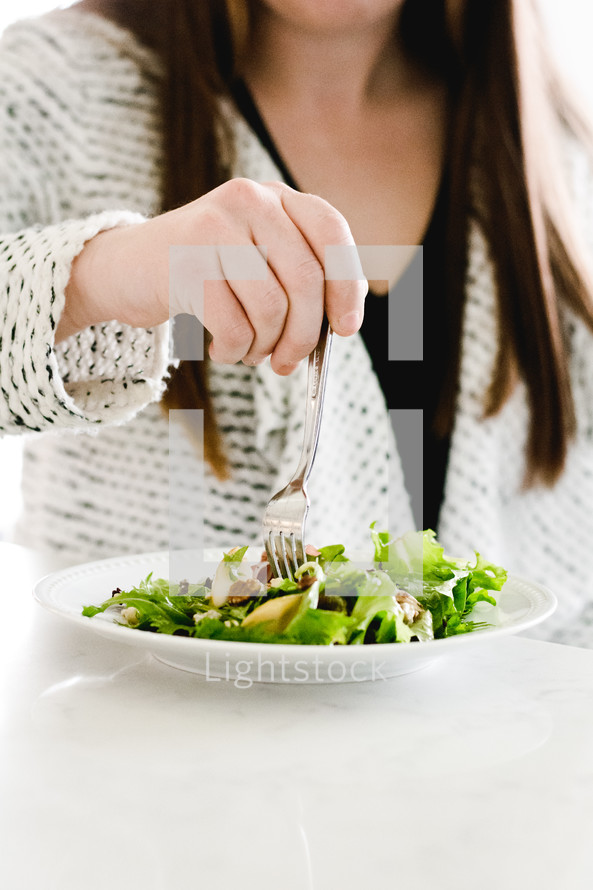 a woman eating a salad 