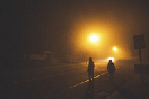 men walking down a dark street 