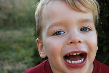 toddler boy showing his teeth 