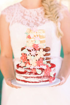 bride holding a wedding cake 