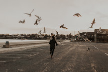 a person chasing seagulls 
