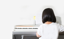 a toddler girl playing a piano 