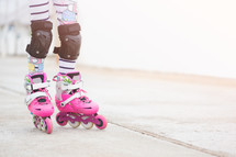 a girl roller blading with knee pads 
