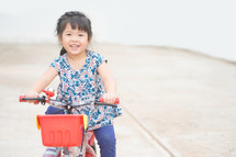a little girl learning to ride a bicycle