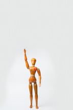 Wooden model character of woman standing and raise hand alone with one heart shape in her heart white background