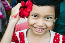 a little girl with a hibiscus flower behind her ear 