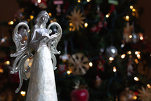 Christmas angel figurine in front of a Christmas tree 