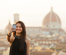 Young Teen takes a selfie at sunset in Florence, Cathedral of Santa Maria del Fiore on the background.