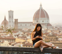 Young Teen takes a selfie at sunset in Florence, Cathedral of Santa Maria del Fiore on the background.