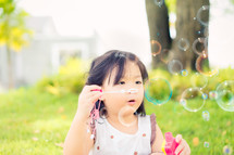 girl blowing bubbles 