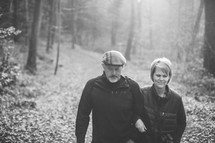 couple walking arm in arm on a trail 