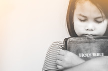 girl hugging a Bible 