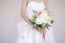 torso of a bride holding her bouquet 
