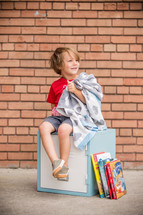 a child holding his security blanket going back to school 