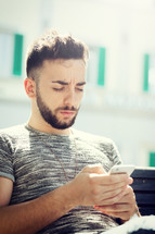 Young man at the park using smartphone on a sunny day