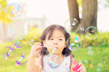little girl blowing bubbles 