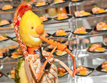 Decoration for buffet made with lobster, lemon and carrot. It is a person who plays the flute.