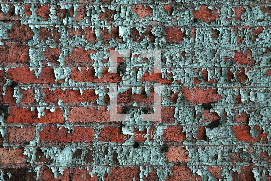 Green paint peeling from red bricks. 