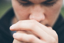 close-up of a man with his hand held in prayer