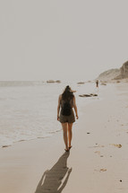 a woman walking on a beach 