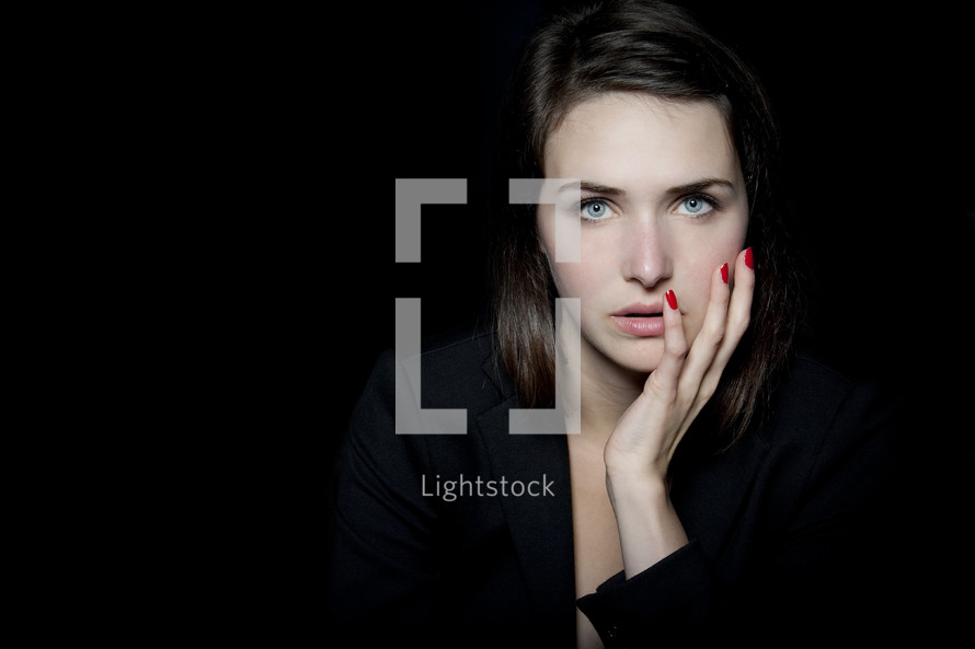 In the Darkness - woman with her hand on her cheek