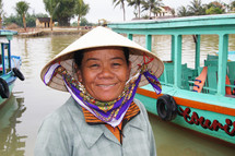 Vietnamese woman in straw hat in front of water taxi's (For more like this, try also search for 'Ethnic Face')