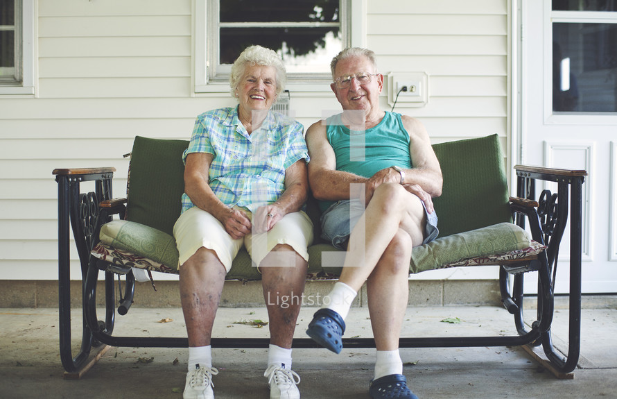 elderly couple sitting on a porch swing