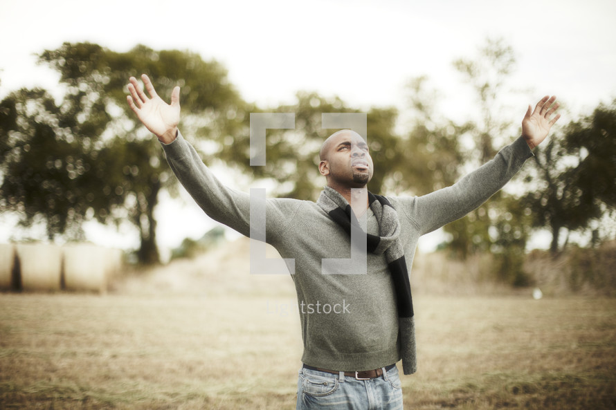 man with his arms raised in worship to God