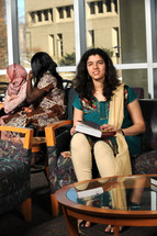 Young girl sitting in a waiting room, other women in the background