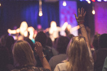 worshipers with raised hands at a worship service 