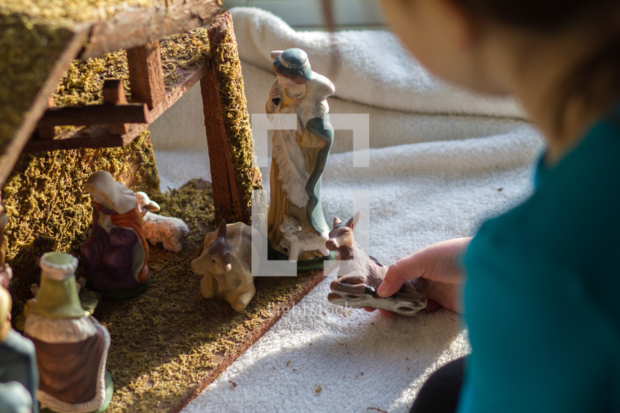 child playing with a nativity scene 