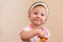 toddler girl holding a toy 