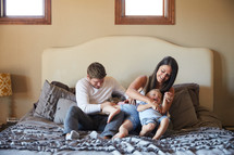 a family sitting on a bed 