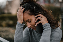 a young woman receiving bad news during a phone conversation 