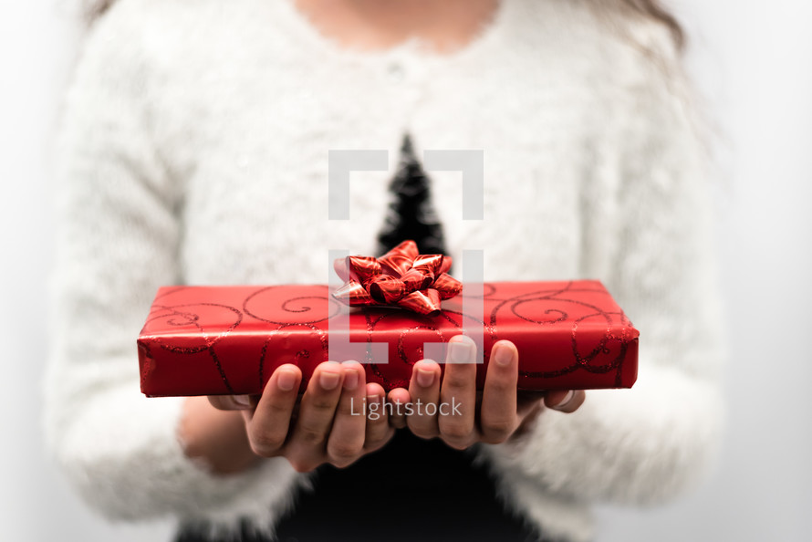 a woman holding a wrapped Christmas present 