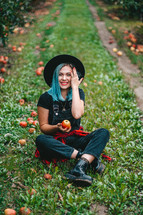  Blue haired girl picked up a lot of ripe red apple fruits from tree in green garden. Organic lifestyle, agriculture, gardener occupation.
