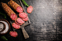 Delicious salami sausage on the table. On a black background. High quality photo