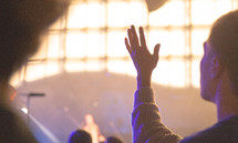 a man with raised hands at a concert 