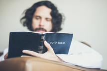 a man reading the Santa Biblia 