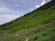 hikers on a trail on a mountainside 
