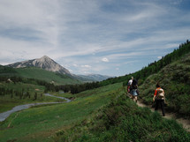 hikers on a nature trail and mountain peak 