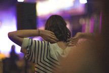 a woman stretching at a concert 