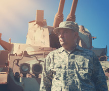 A soldier in front of an army tank
