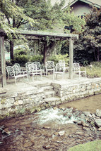 white chairs lined up in front of a brook 