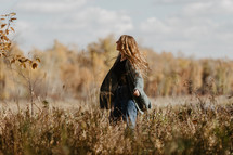 a woman standing outdoors in fall 