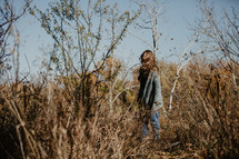 a woman standing in a field in fall 
