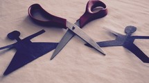 scissors between a man and woman paper doll 